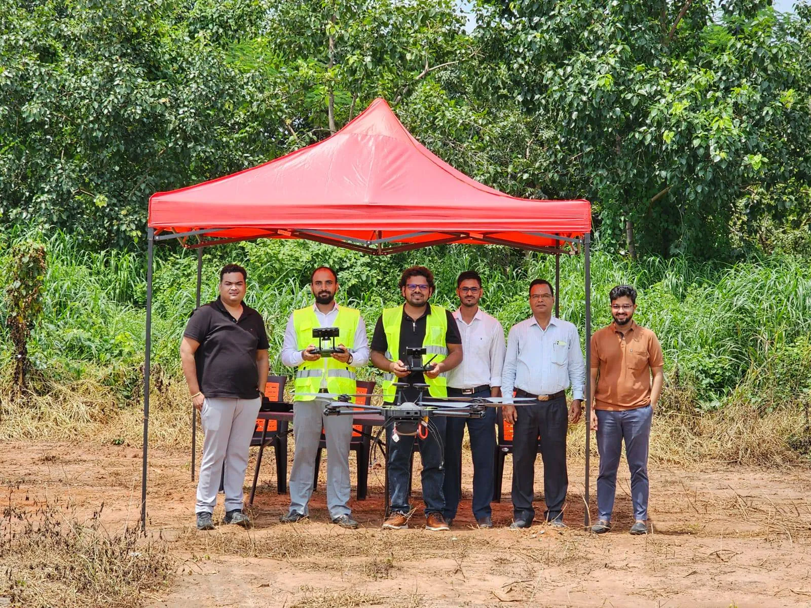 Precision Airborne team members with drone equipment at an outdoor field site